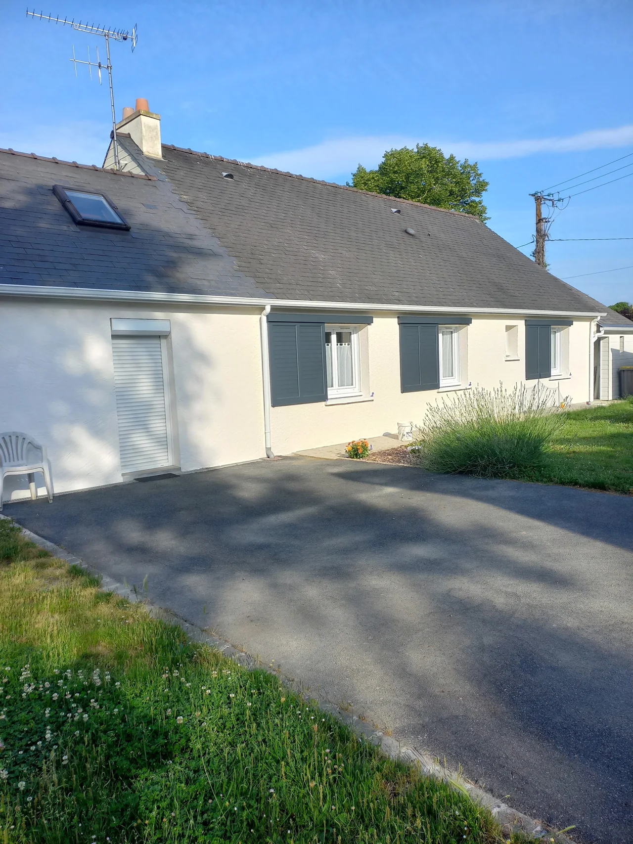 Façade claire d’une maison avec des volets blancs
